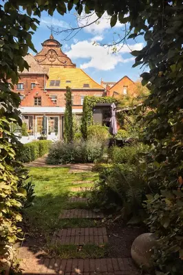 a garden with a large building in the background at Casa della Nonna in Diest