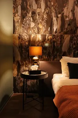 a bedroom with a bed and a table with a lamp at Casa della Nonna in Diest