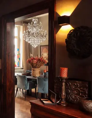 a dining room with a chandelier and a table in a mirror at Casa della Nonna in Diest