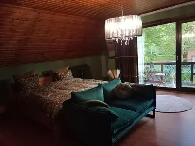 a bedroom with a bed and a couch and a chandelier at Efes home in Ghent