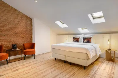 a bedroom with a bed and a brick wall at The 1894 Boutique Holiday Apartment in Antwerp