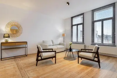 a living room with a couch and a table and chairs at The 1894 Boutique Holiday Apartment in Antwerp