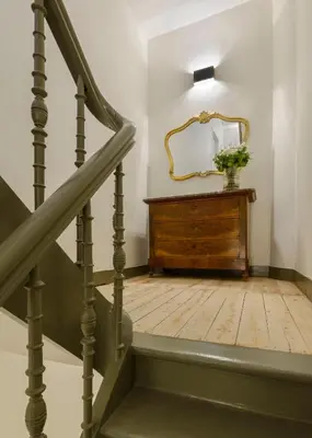 a staircase with a mirror and a wooden dresser at Our Bird's Nest in the Heart of Antwerp in Antwerp