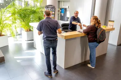 a man and a woman standing at a counter at Youth Hostel van Gogh in Brussels