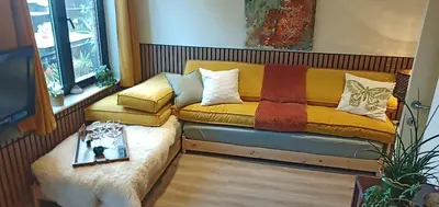 a couch with pillows on it in a room at LodgeRivierenhof in Antwerp
