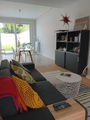 a living room with a black couch and a table at Spacieux Appartement 1 chambre double & jardin in Brussels