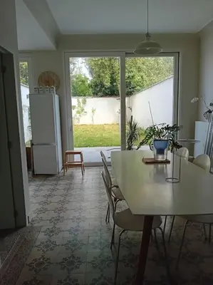 a kitchen with a white table and chairs and a refrigerator at Spacieux Appartement 1 chambre double & jardin in Brussels