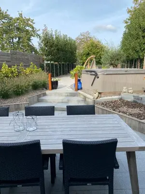 a wooden table and chairs in a garden at Miranius Rey in Lede