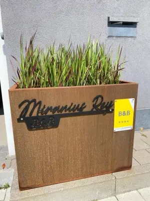 a large wooden box with plants in front of a building at Miranius Rey in Lede