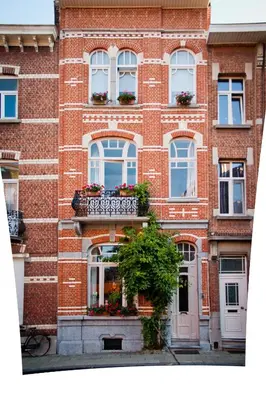 a red brick building with windows and a plant at B&B Lodging At 8 in Leuven