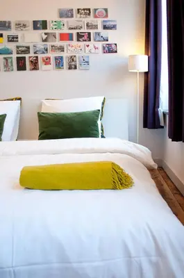 a white bed with a yellow blanket on it at B&B Lodging At 8 in Leuven
