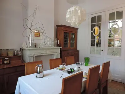 a dining room with a white table and chairs at B&B Lodging At 8 in Leuven