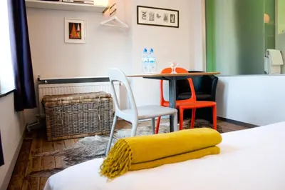 a room with a table and chairs and a bed at B&B Lodging At 8 in Leuven
