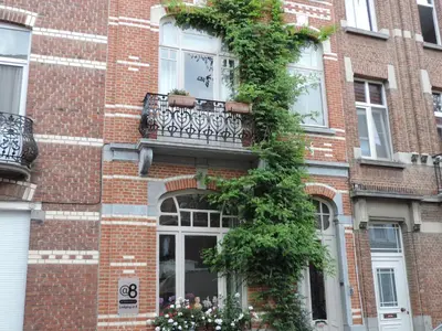 a brick building with a balcony and a window at B&B Lodging At 8 in Leuven