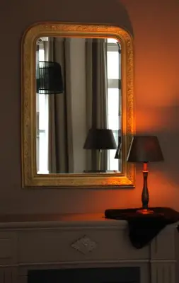 a mirror and a lamp on a dresser in a room at Antwerp White House in Antwerp