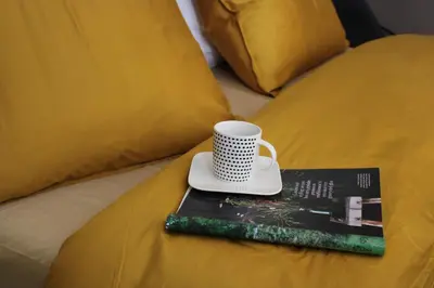 a book with a cup on top of it on a bed at Antwerp White House in Antwerp