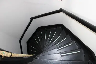 a black spiral staircase in a white wall at Antwerp White House in Antwerp