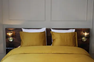 a bedroom with a yellow bed with two pillows at Antwerp White House in Antwerp