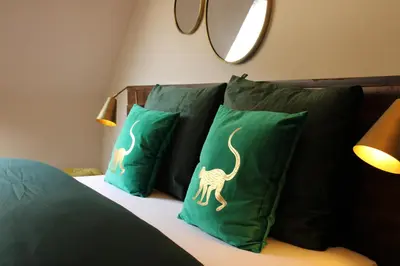 a bed with green pillows with dinosaurs on them at Antwerp White House in Antwerp