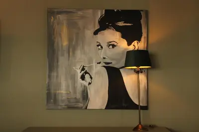 a painting of a woman on a wall next to a lamp at Antwerp White House in Antwerp
