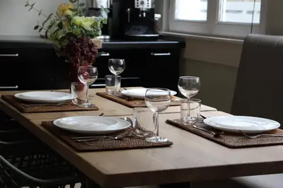 a table with plates and wine glasses on it at Antwerp White House in Antwerp