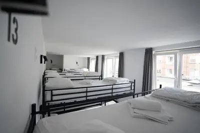 a group of beds in a room with a window at The ASH in Antwerp