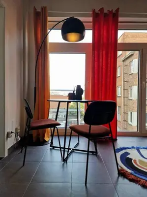 a table and chairs in a room with a window at Hakuna Matata @ Opera in Antwerp