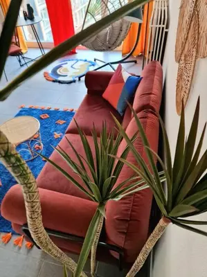a red couch with pillows sitting in a living room at Hakuna Matata @ Opera in Antwerp