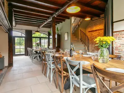 a dining room with wooden tables and chairs at Alverwege 2 in Merksplas