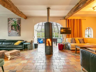 a living room with a fireplace in the middle at Alverwege 2 in Merksplas
