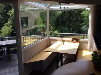 a balcony with a table and a large window at B&B Uccle in Brussels