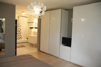 a bedroom with a bed and a chandelier at B&B Uccle in Brussels