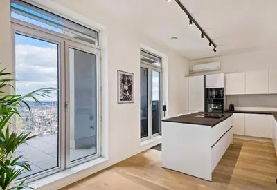 a kitchen with white cabinets and a large window at Sky loft - Luxurious Penthouse - Antwerp 180 m² in Antwerp
