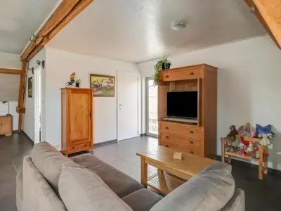 a living room with a couch and a tv at In de Wollekjes in Merksplas