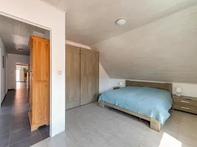 a bedroom with a bed and a wooden ceiling at In de Wollekjes in Merksplas