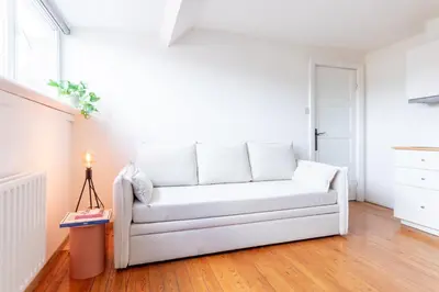 a white couch sitting in a living room at Guesthouse private studio nearby old town Ghent in Ghent