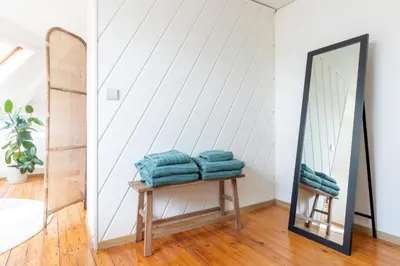 a mirror sitting next to a table with towels at Guesthouse private studio nearby old town Ghent in Ghent