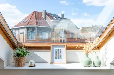 a window with vases on a shelf with a house at Guesthouse private studio nearby old town Ghent in Ghent