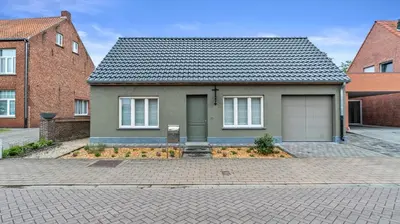 a house with a garage in front of two brick buildings at An's Vakantiehuisje in Dessel