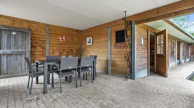 a dining room with a table and chairs on a patio at An's Vakantiehuisje in Dessel