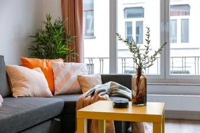 a living room with a couch and a table with a vase at Colorful POP apartment in the heart of Antwerp in Antwerp