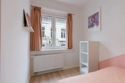 a bedroom with a bed and a window and a shelf at Colorful POP apartment in the heart of Antwerp in Antwerp
