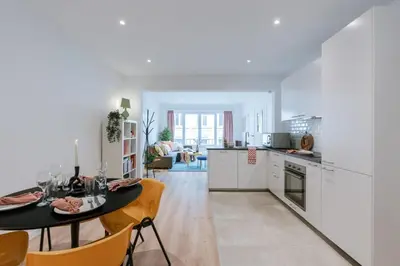 a kitchen and living room with a table and chairs at Colorful POP apartment in the heart of Antwerp in Antwerp