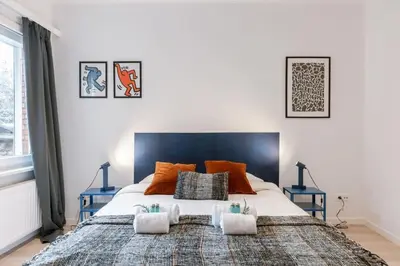 a bedroom with a large bed with orange pillows at Colorful POP apartment in the heart of Antwerp in Antwerp