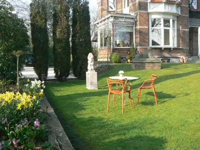 two chairs and a table in the yard of a house at B&B Villa Emma in Ghent