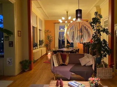 a living room with a couch and a chandelier at B&B Villa Emma in Ghent