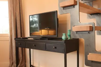 a television on a black dresser in a room at B&B Villa Emma in Ghent