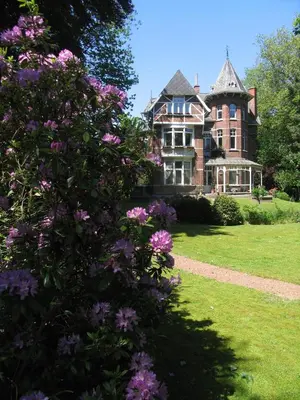 an old house with pink flowers in front of it at B&B Villa Emma in Ghent