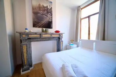 a bedroom with a fireplace and a white bed at Easy Stay - City Center in Brussels