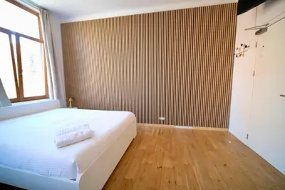 a bedroom with a large white bed and a window at Easy Stay - City Center in Brussels